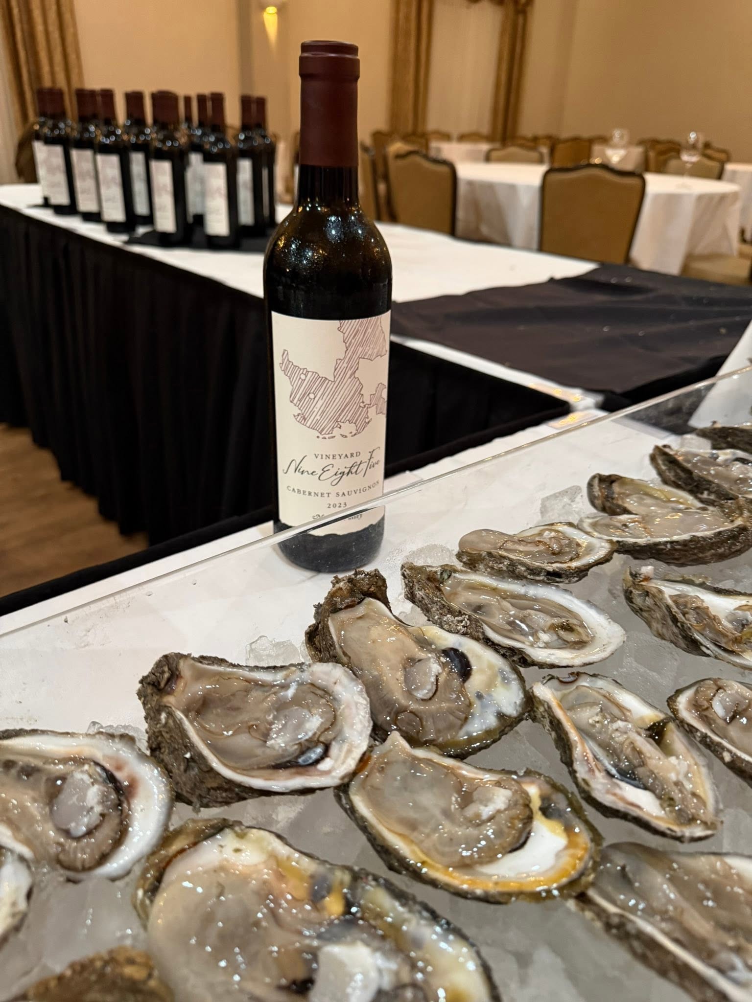 Freshly shucked oysters on ice beside a bottle of Vineyard 985 Cabernet Sauvignon at last year’s release party